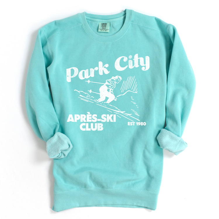Park City Après Ski Club Comfort Colors lightweight crewneck sweatshirt featuring a female skier design with vintage retro grunge vibes, ideal for ski trips and winter getaways.