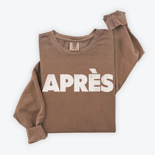 Comfort Colors lightweight crewneck sweatshirt with "Après" in bold print and a faded vintage grunge look, ideal for casual winter and après-ski occasions.