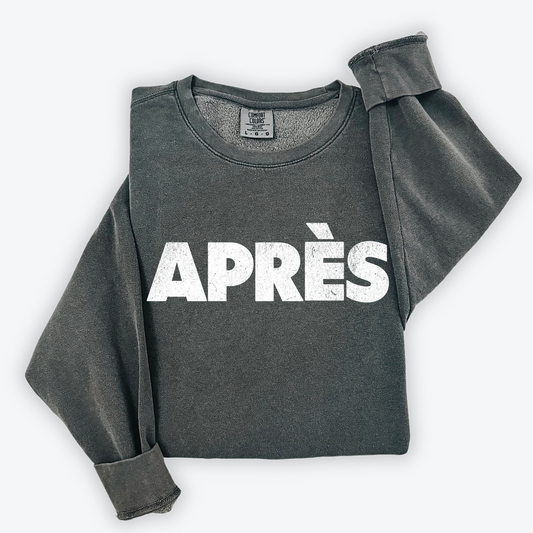 Comfort Colors lightweight crewneck sweatshirt with "Après" in bold print and a faded vintage grunge look, ideal for casual winter and après-ski occasions.