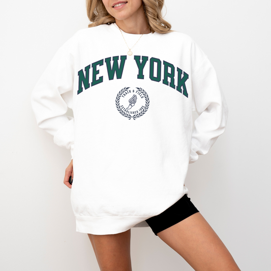 A Comfort Colors lightweight cotton crewneck sweatshirt with "New York Track & Field" printed in vintage retro style, giving a refined old money look.