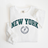A Comfort Colors lightweight cotton crewneck sweatshirt with "New York Track & Field" printed in vintage retro style, giving a refined old money look.